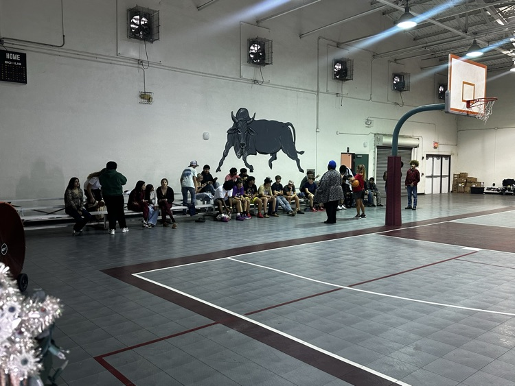 students watching kids play basketball