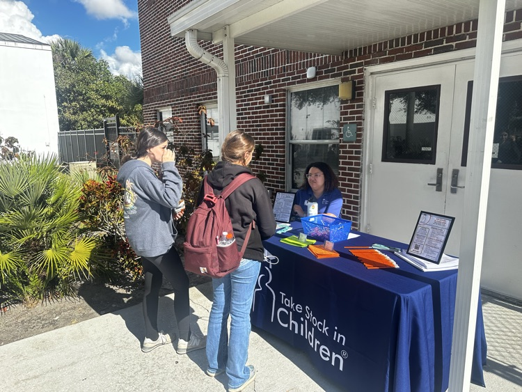 students talking to adult in booth