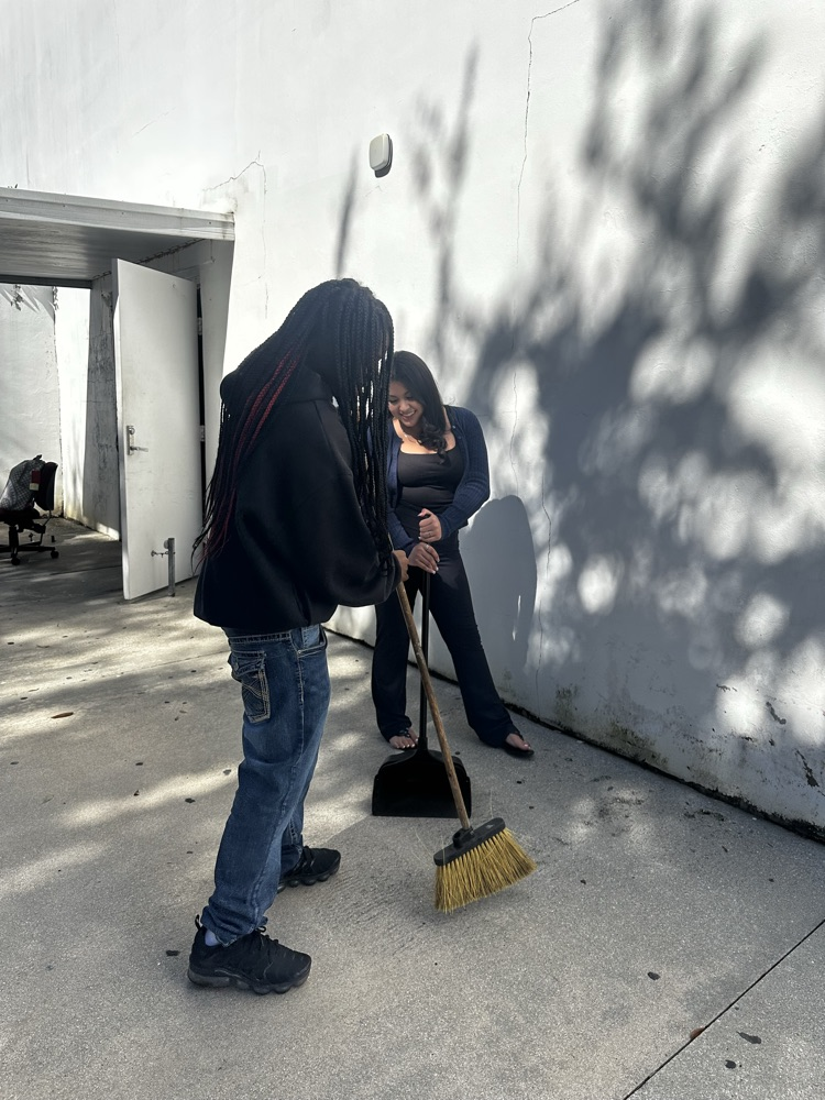 two students helping clean outside school