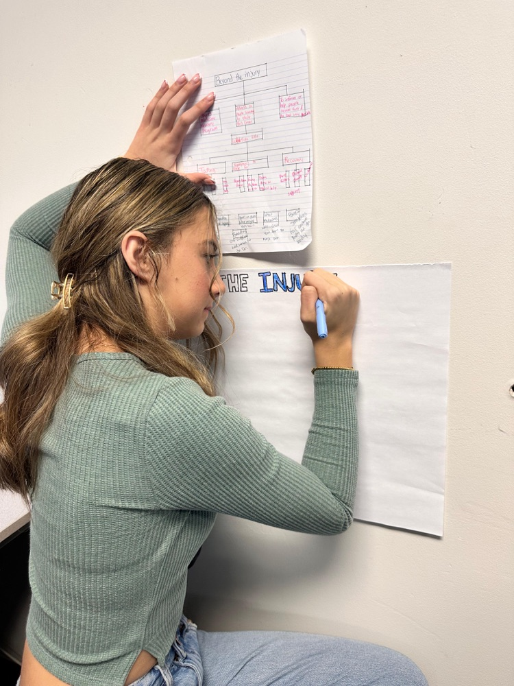 student writing on poster