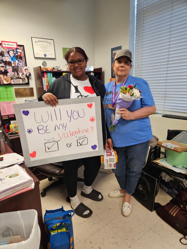 teacher and student with sign about Valentine 