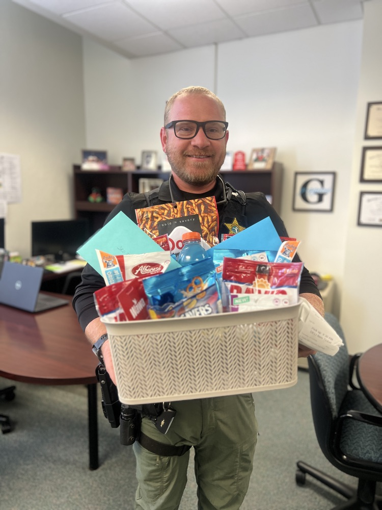 school resource officer holding a basket in principal office