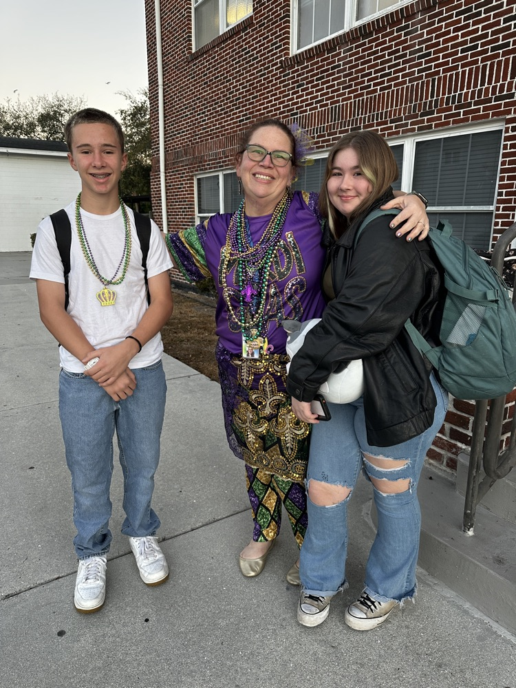 teacher and two students celebrating Mardi Gras
