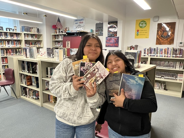 two students with books in library