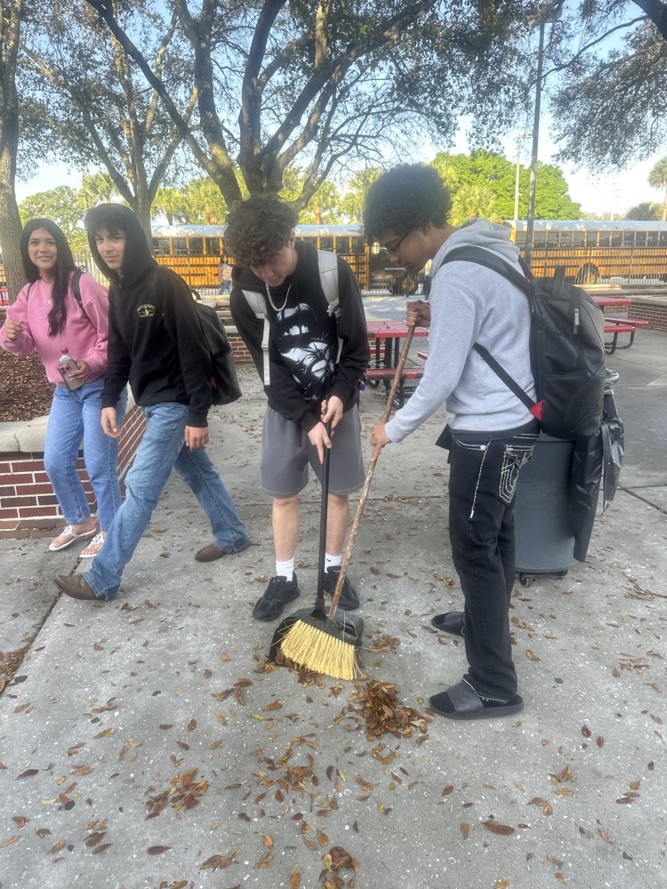students picking up leaves