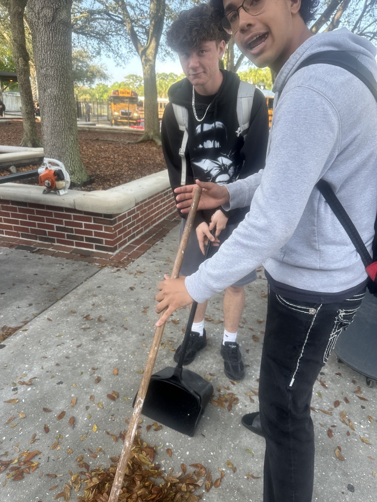 students picking up leaves 