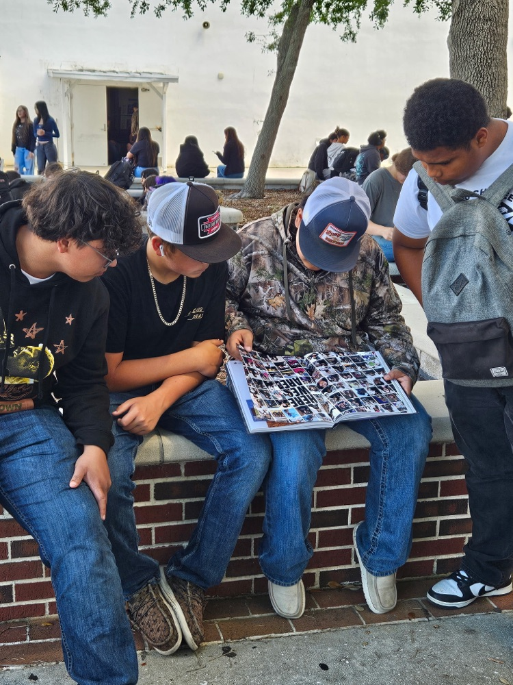 students looking at yearbook S