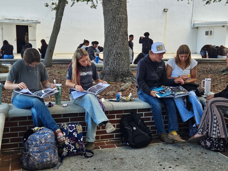 students looking at yearbook S