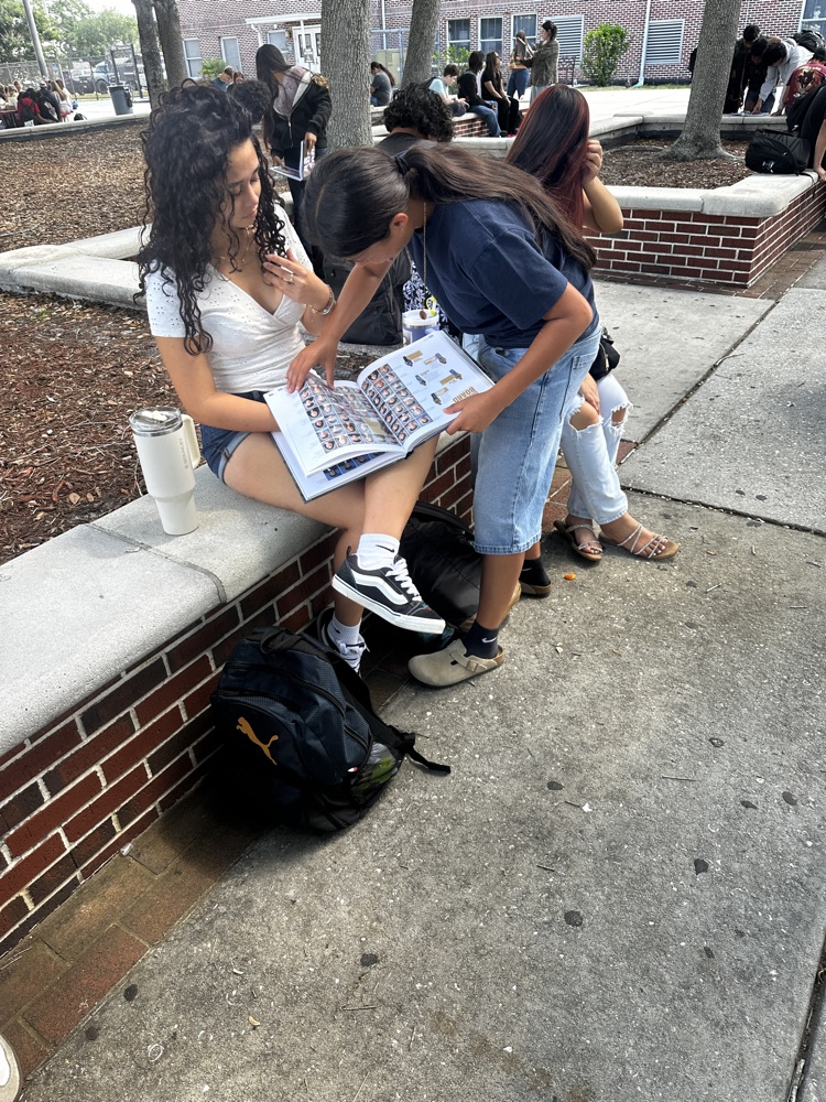 students looking at yearbook S