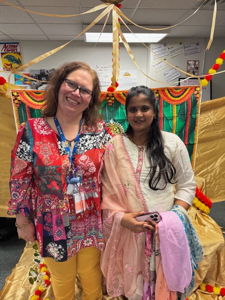 two teachers dressed for Indian baby shower in classroom