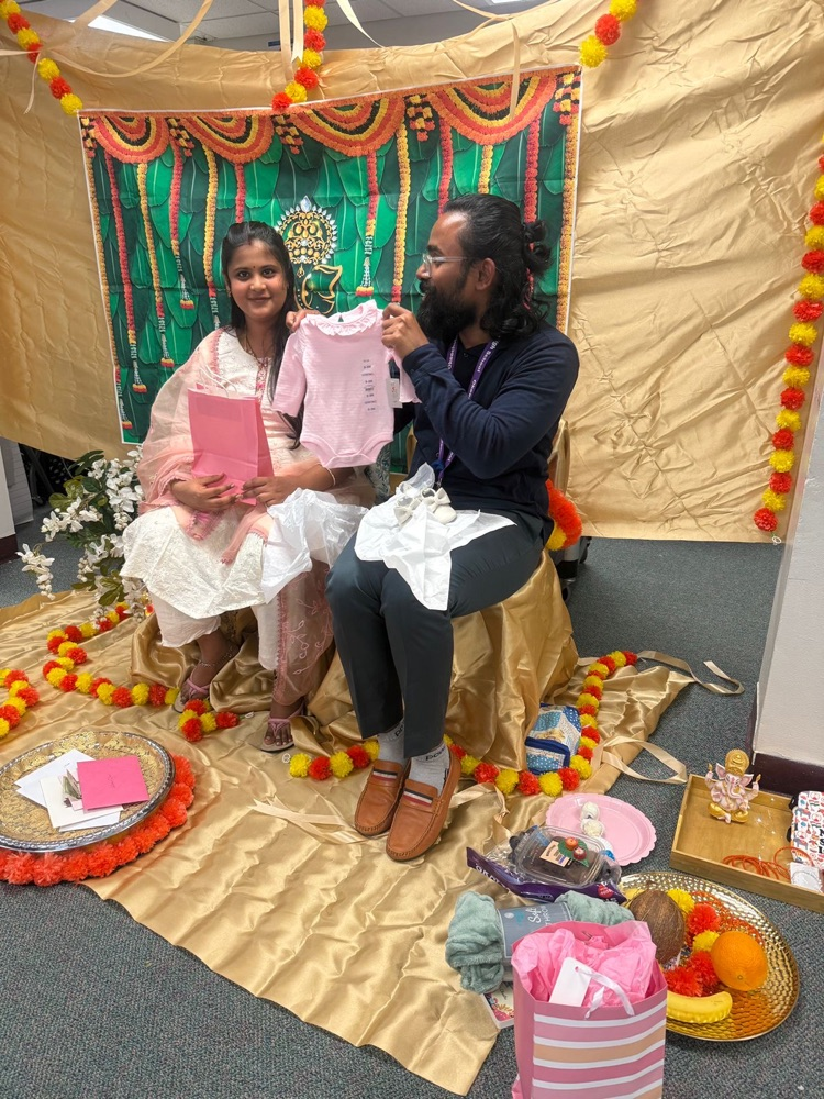 Indian baby shower with male showing onesie