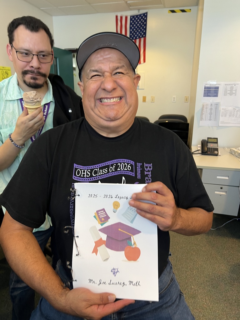 teacher holding letters from students making a funny face