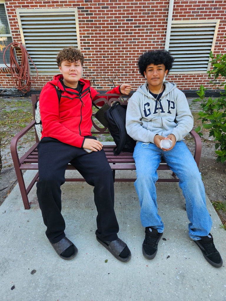 two students sitting in courtyard bench