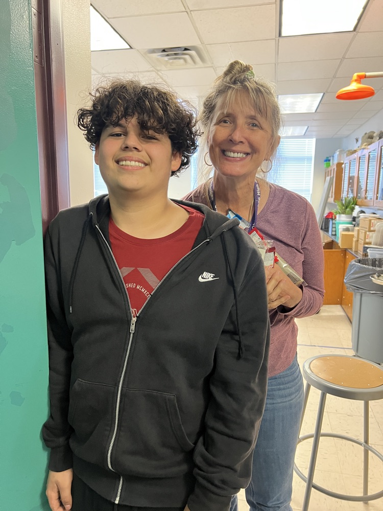 teacher grabbing snacks from cart with student