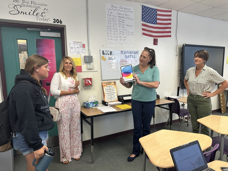 three teachers gifting a student a new iPad 
