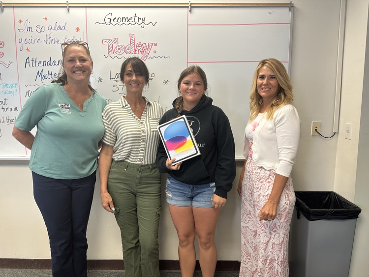 three teachers gifting a student a new iPad 
