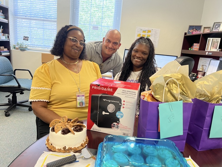 three staff members celebrating birthday in principals office