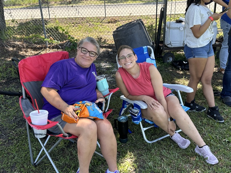 two teachers in field sitting