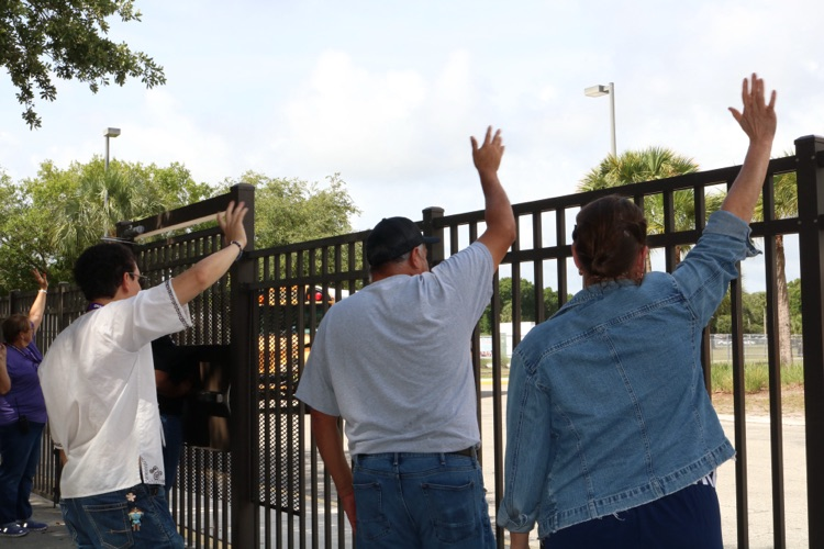 teachers waving goodbye at busses