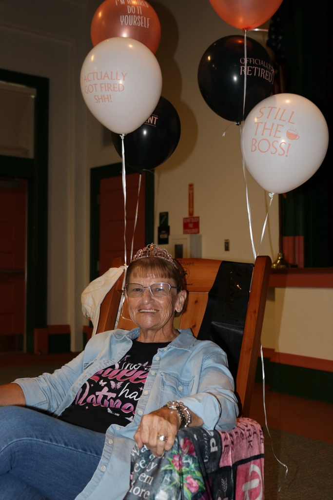 school member sitting in chair at retirement party 