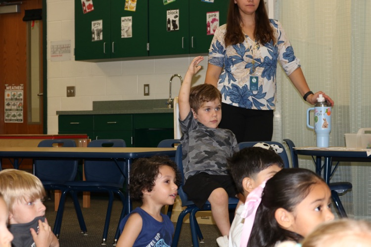 students sitting and then a student raising hand