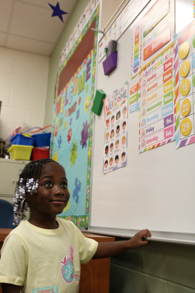 vpk student by board smiling