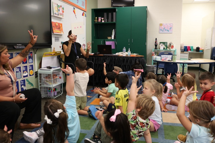 teacher teaching students sitting on floor
