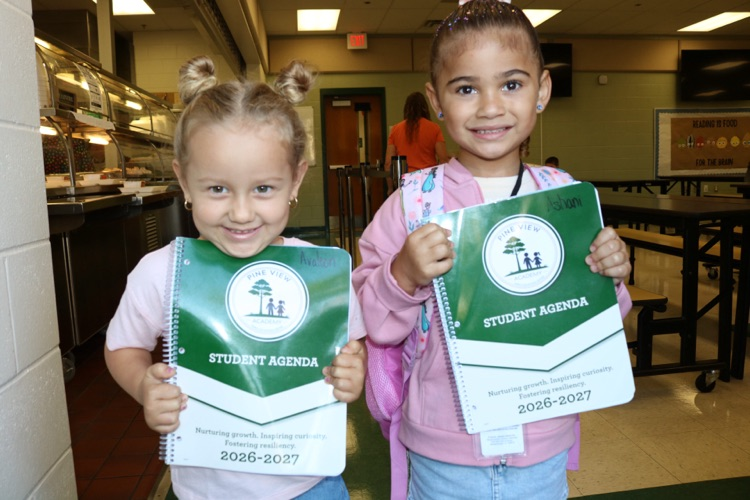 two students holding agendas