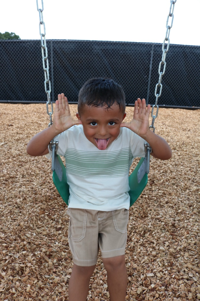 student sticking tongue out on swing 