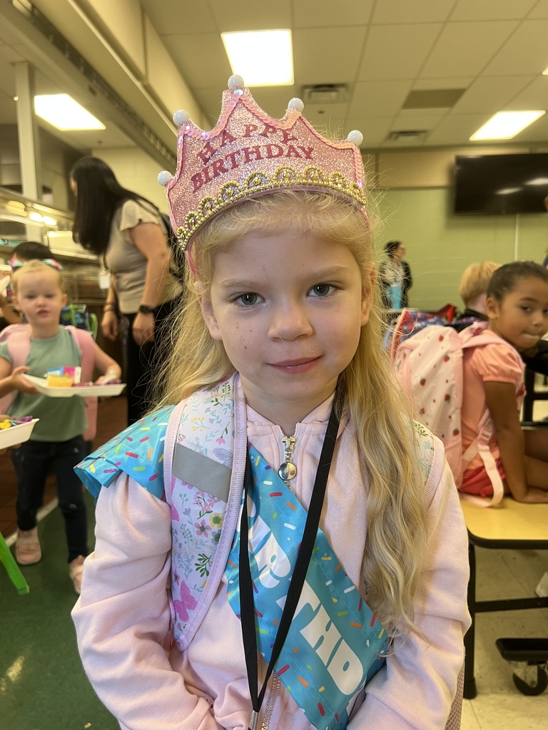 student wearing birthday crown and sash in cafeteria