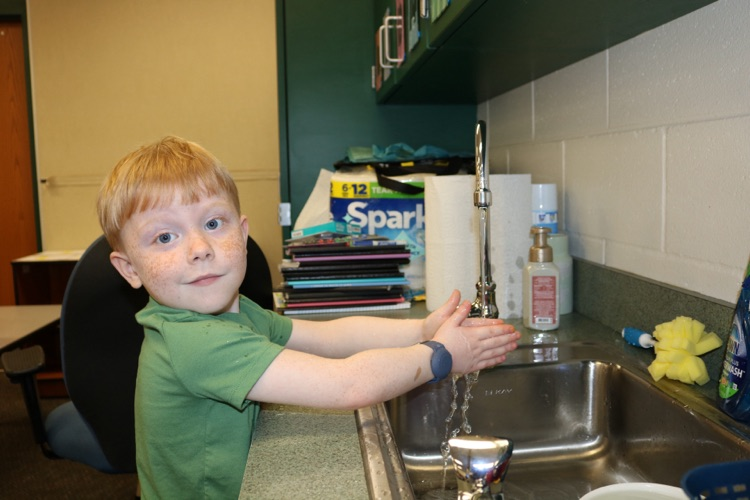 student washing his hands 