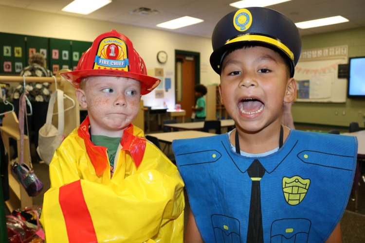 two students playing dress up firefighter and cop