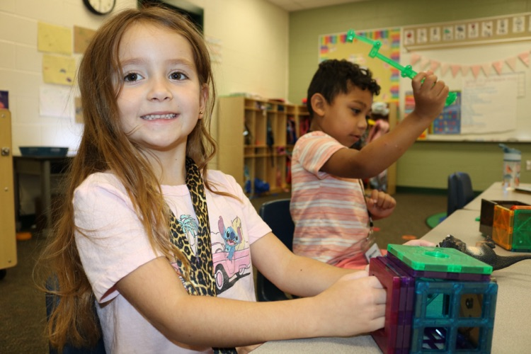 two students playing with magnet tiles 