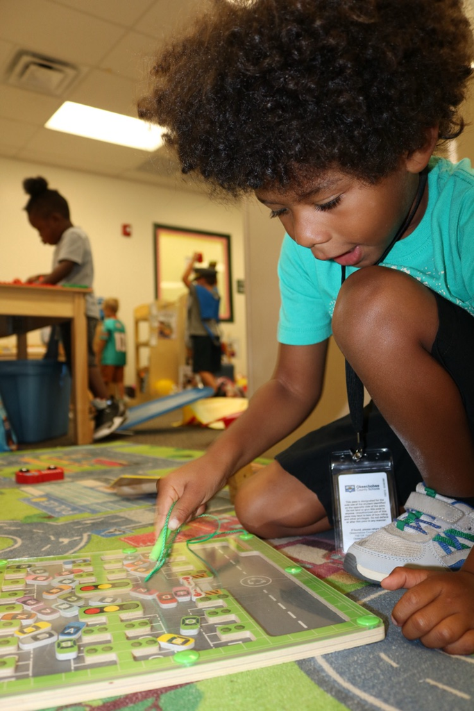 student playing with magnet toy in class floor