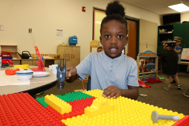 student with playing legos