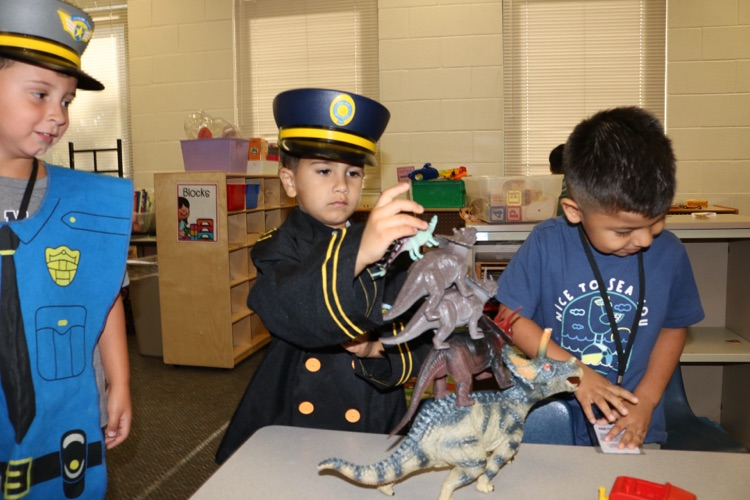 students playing with dinosaur toys
