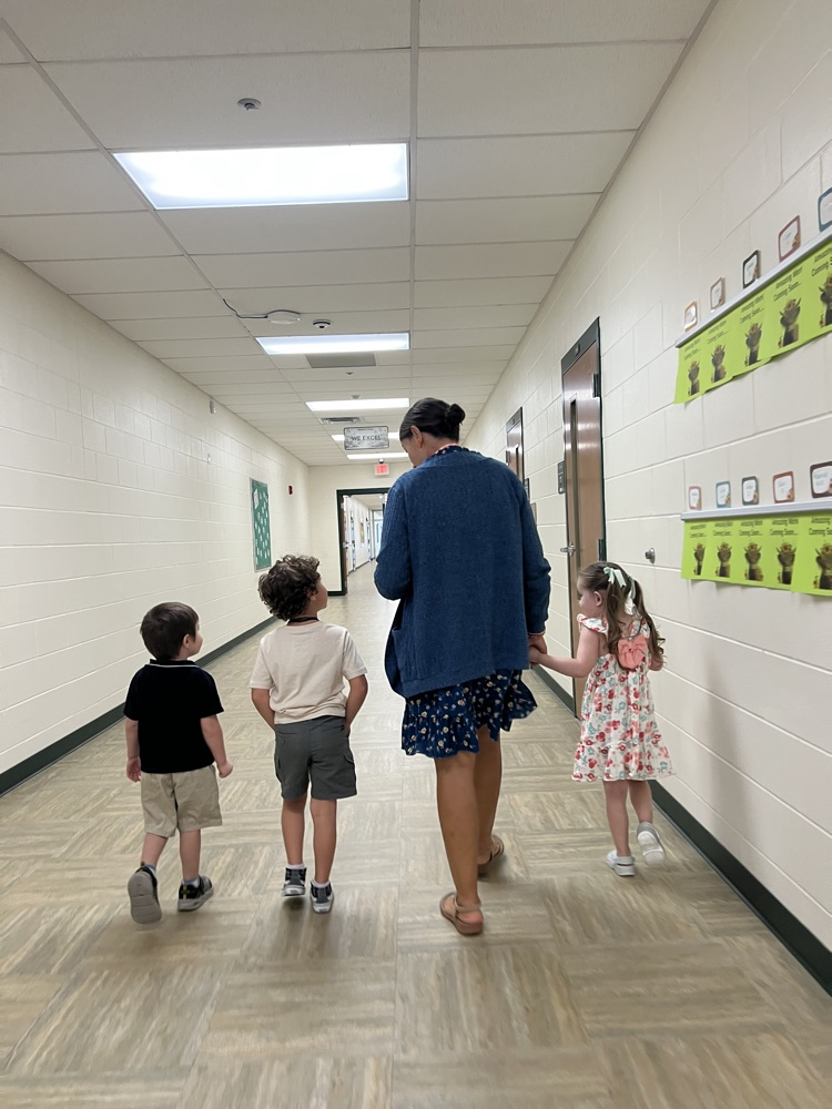 teacher walking with students to testing room