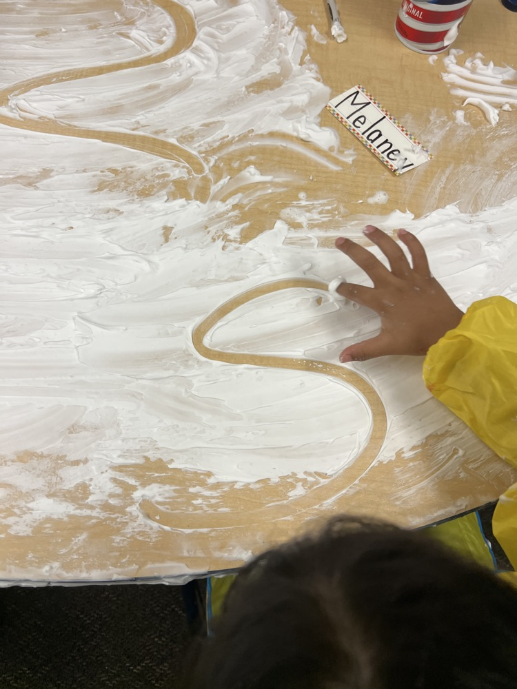 student writing S on foam
