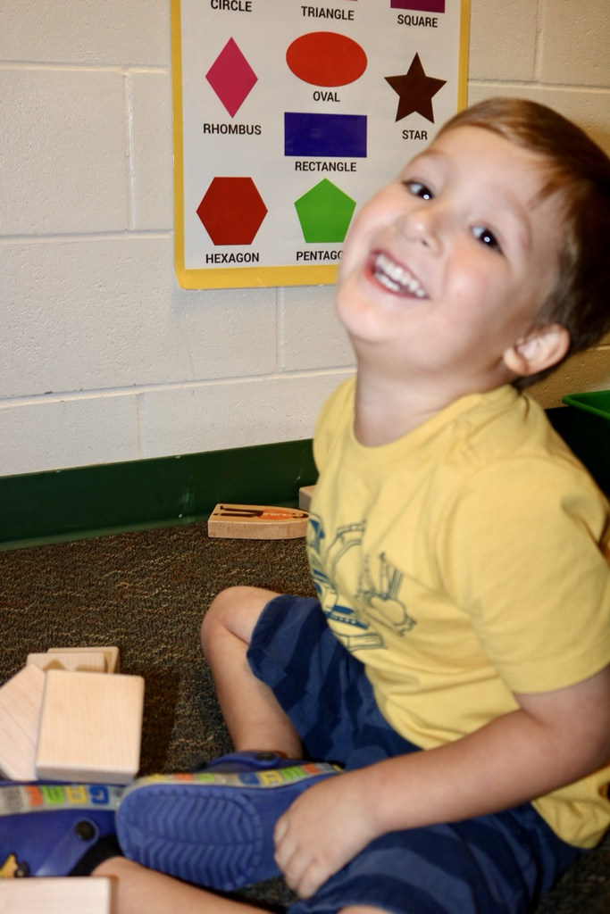 student smiling playing with blocks