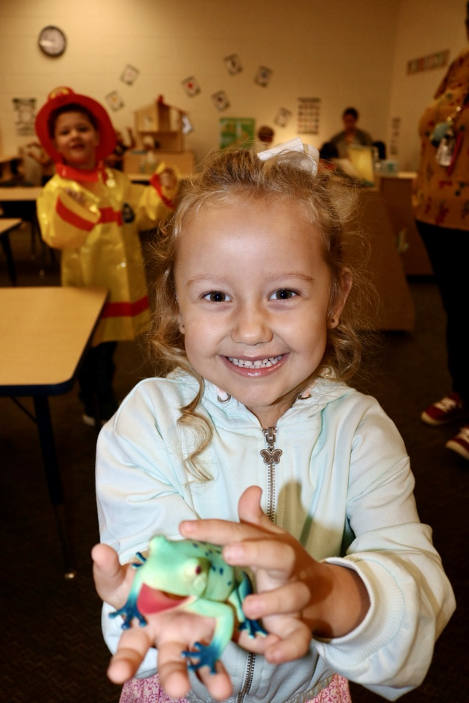 student showing dinosaur toy