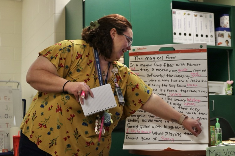 teacher pointing to poster paper