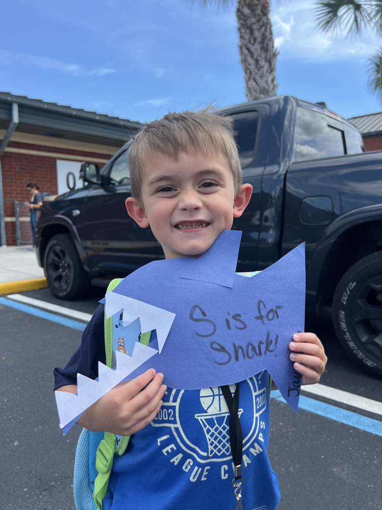 student showing shark project at dismissal 