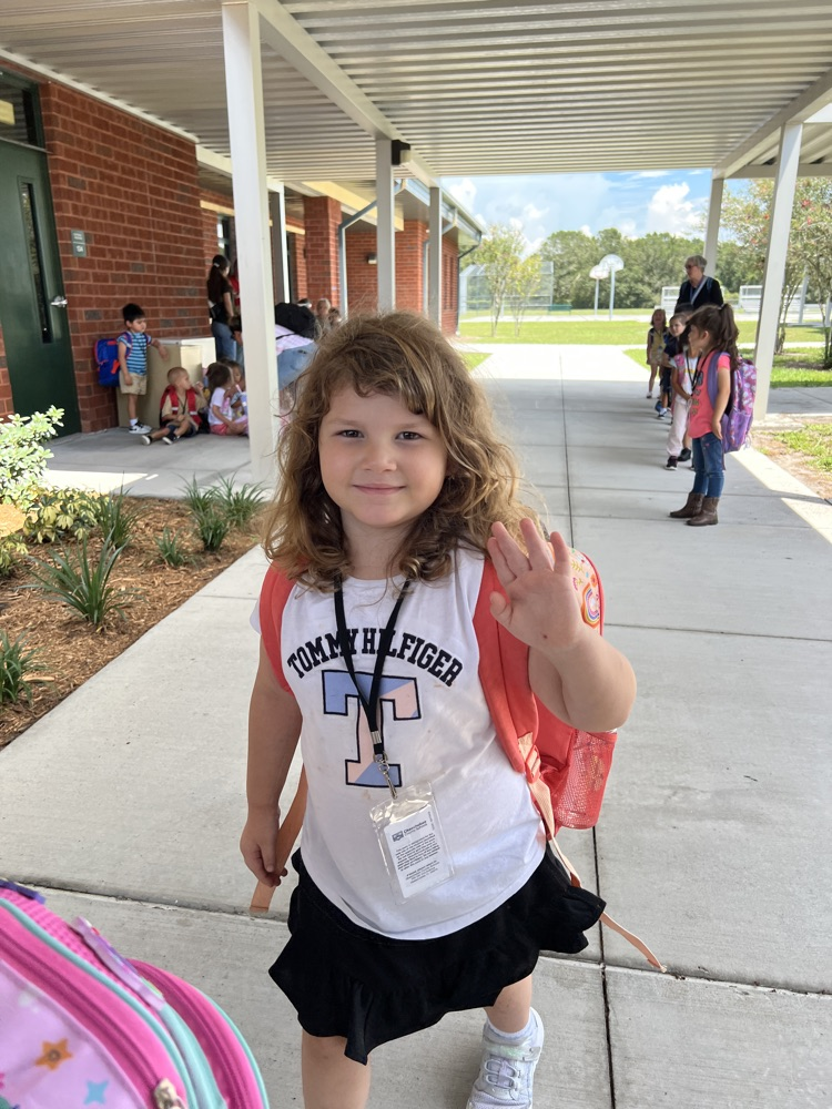 student waving goodbye at pick up