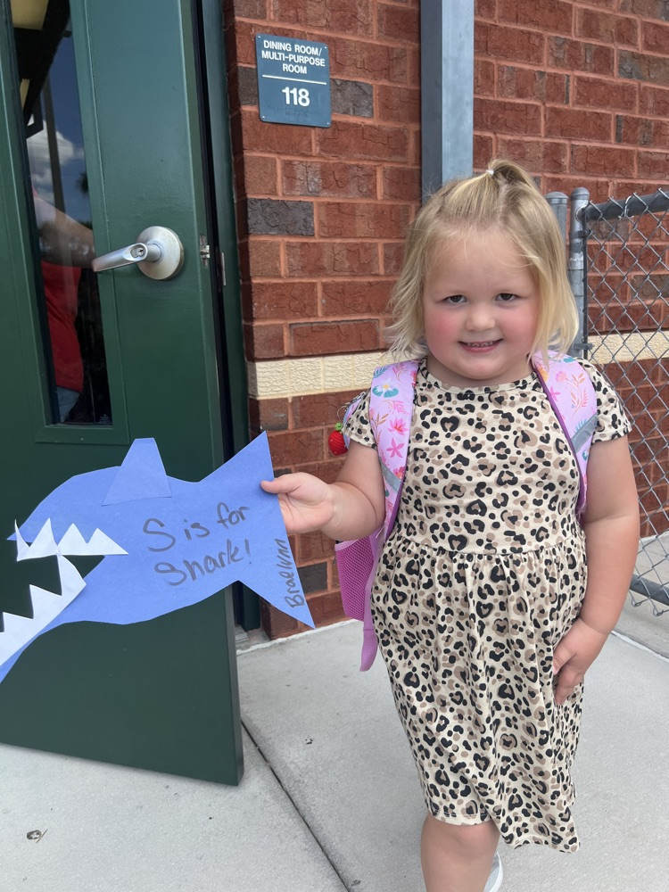 student showing shark project at parent pick up