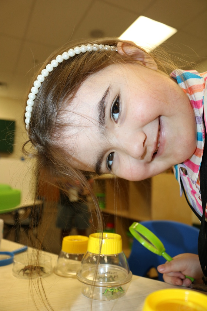 student smiling and playing with science toys
