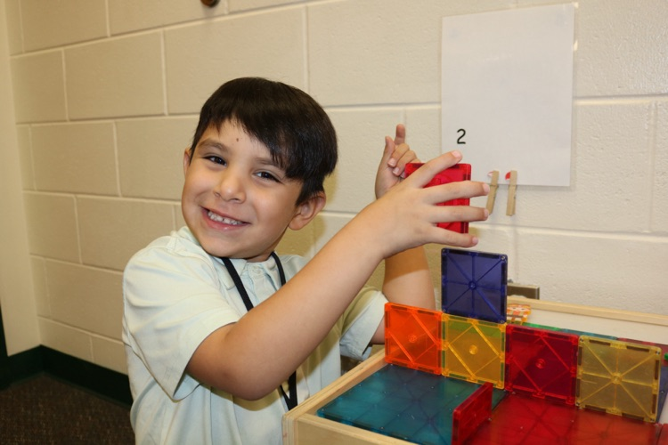 student playing with toy tiles 