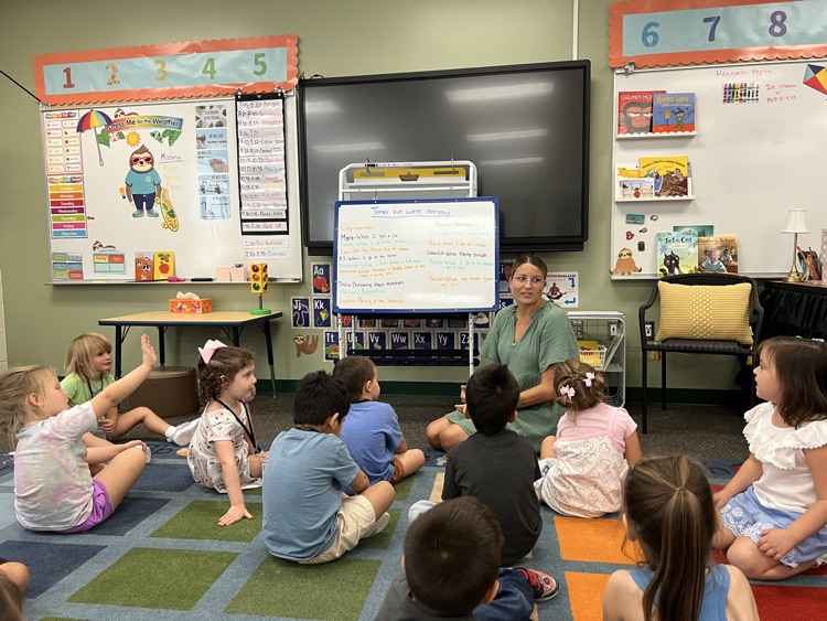 students sitting in rug with teacher