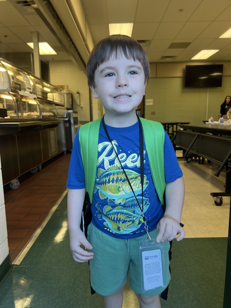 student wearing blue and green for spirit day in cafeteria 