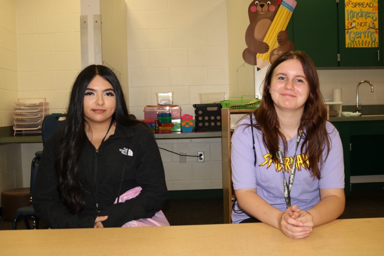two high school girls visiting prek class