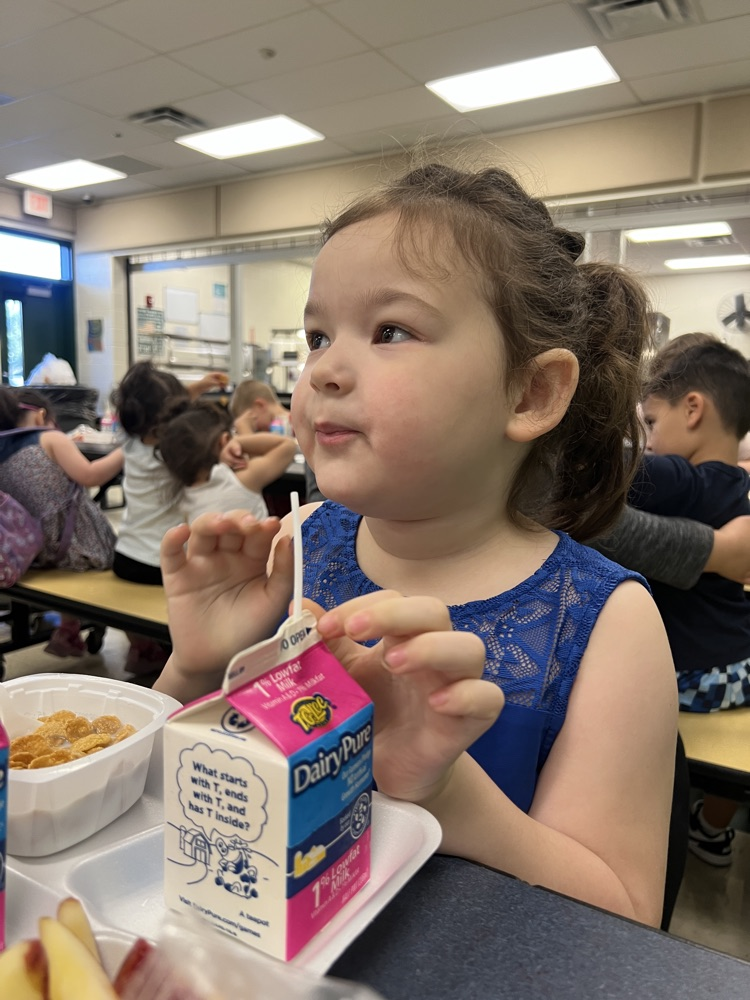 student wearing blue eating breakfast